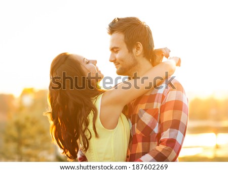 Young couple in love walking in the park near the river.