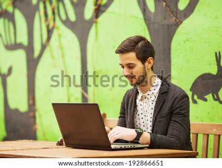 Happy man working on laptop on cafe