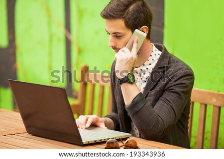Happy man working on laptop on cafe