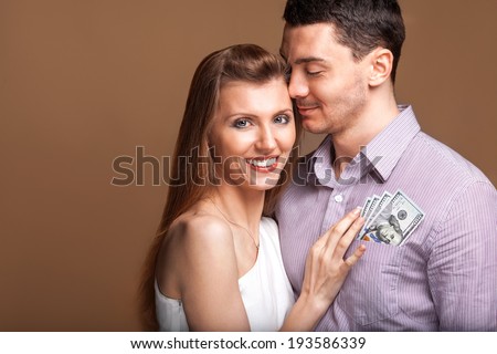 Fashion beautiful couple in love holding money the family budget. Business concept