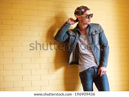 sexy fashion man with beard dressed casual smiling brick wall