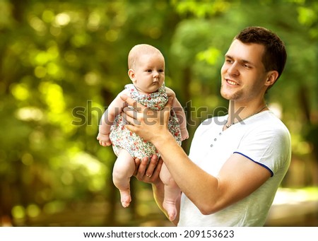 dad and newborn daughter playing in the park in love