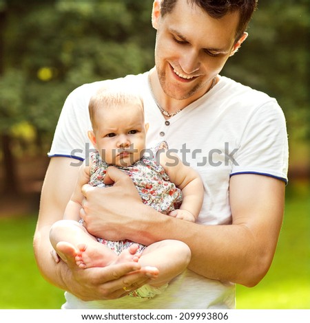 dad and baby daughter playing in the park in lovedad and baby daughter playing in the park in love