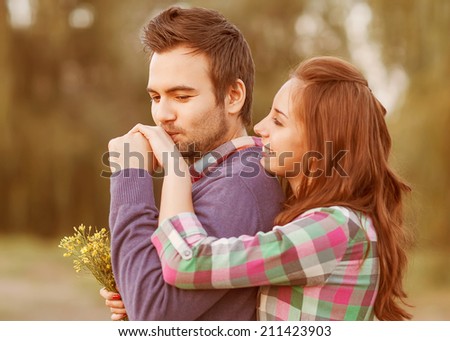 guy kisses the girl\'s hand in park