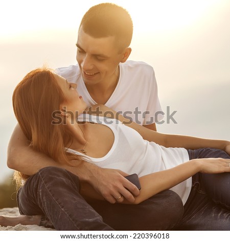 Young couple in love outdoor. They are smiling and looking at each other.