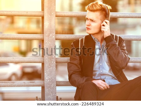 guy hipster listens to the player on the street