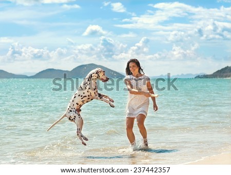 young girl with a dog walking on the sea