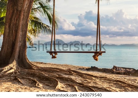 A wooden swing in a tree on the beach with beautiful views of the island, Thailand