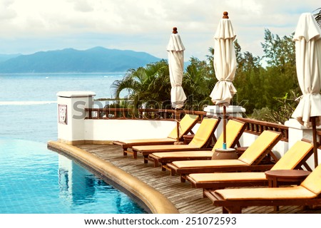 swimming pool with beds overlooking the sea and mountains