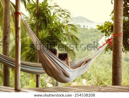 man lying in a hammock freelancer and running, beautiful mountain views, drinking wine