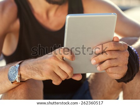 sunny tablet in the hands of the guy on the nature