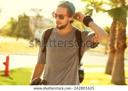 Hipster style guy. Fashion man on street palm at sunset