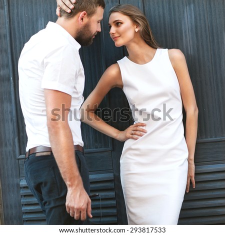 fashion couple standing in the European quarter, in a white dress, posing love at sunset