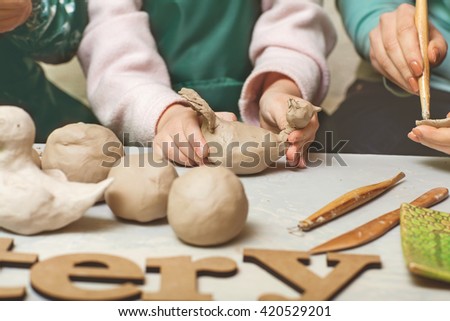girls and mother teen potter clay bowl working in pottery workshop traditional Arts. The inscription on the pottery table