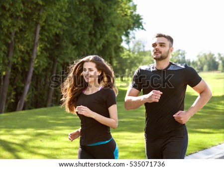 Two runners sprinting outdoors - Sportive people training in a urban area, healthy lifestyle and sport concepts
