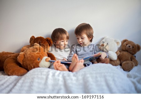 Two boys reading a book educating themselves Two boys reading a book educating themselves