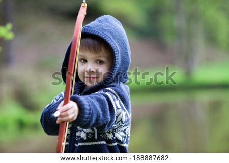 Boy shoots with bow at a target, in the open air