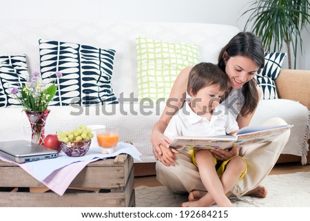Mother and child, reading a book and eating fruits