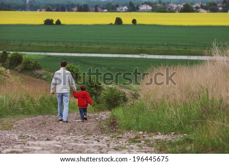 Father and son, walking in a field
