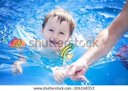 Boy with his father, having fun in the pool