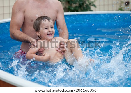 Boy with his father, having fun in the pool