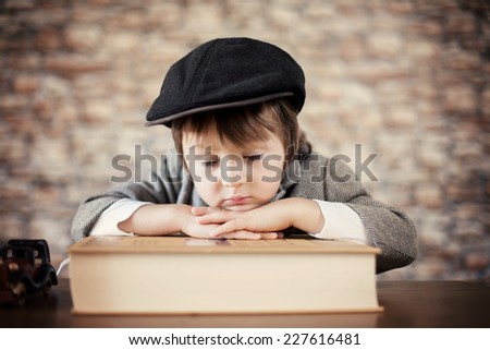Close portrait of boy with big book, indoor
