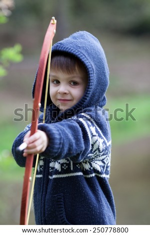 Boy shoots with bow at a target, in the open air