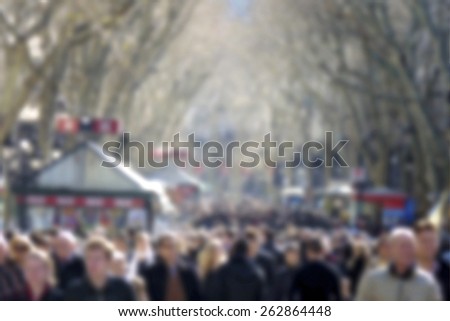 Background blur of crowd of walking people in the city, street, trees