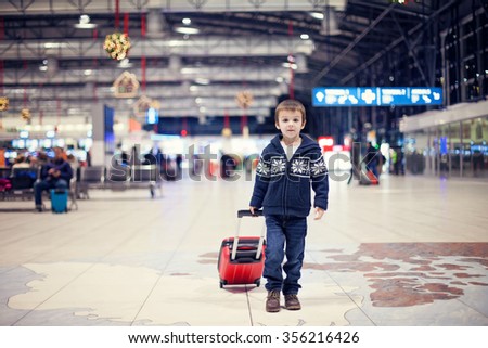 Cute little boy, traveling home for the holidays, Christmas time, waiting happily for the plane to departure
