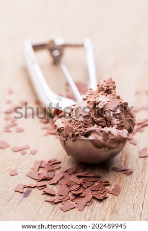 A scoop of chocolate ice cream with chocolate flakes