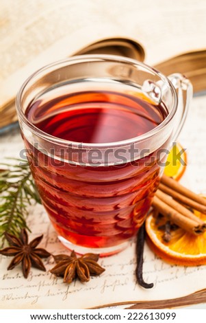 Hot spiced wine with spices on an old cookbook