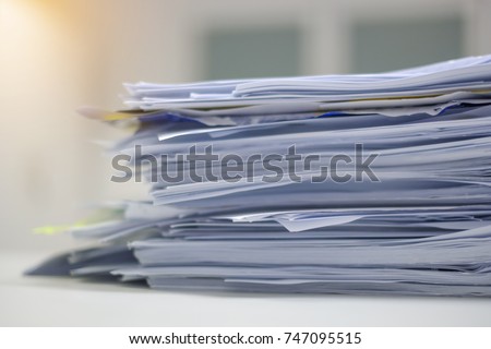 Document pile on office desk, Stack of business paper on the table with blurred of meeting room interior background. job interview and busy business concepts.