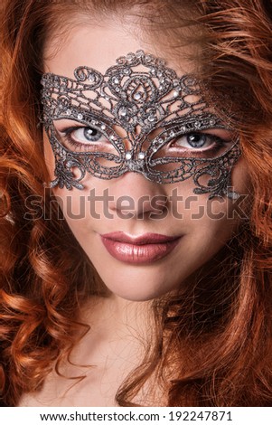 Beautiful Girl in a Carnival mask. Masquerade. Beauty portrait redhead girls.Girl with lush hair.Ginger hair.Woman with voluminous hair