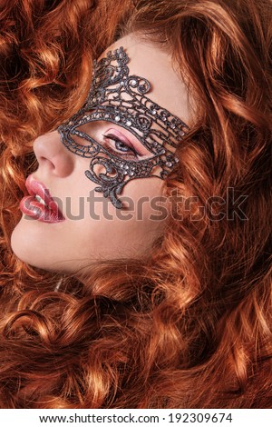 Beautiful Girl in a Carnival mask. Masquerade. Beauty portrait redhead girls.Girl with lush hair.Ginger hair.Woman with voluminous hair