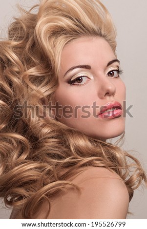 Beauty portrait of a beautiful blonde. Young girl with more voluminous hair. Professional makeup