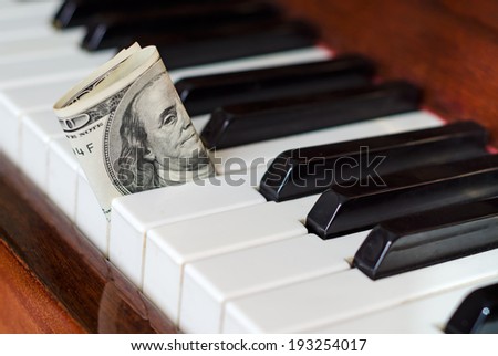 One hundred dollar bill stuck in a piano. Franklin stare. Earn from music.