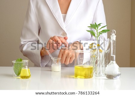 the scientist,dermatologist testing the organic natural product in the laboratory.research and development beauty skincare concept.blank package,bottle,container .cream,serum.hand