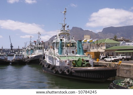 A view of tug boats in Cape Town Harbor with Table Mountain in the background