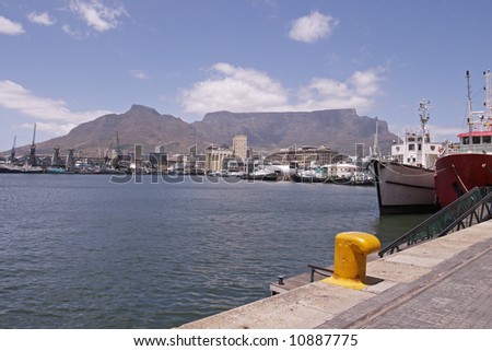 A view of Cape Town Harbor with ships in the foreground and Table Mountain in the background