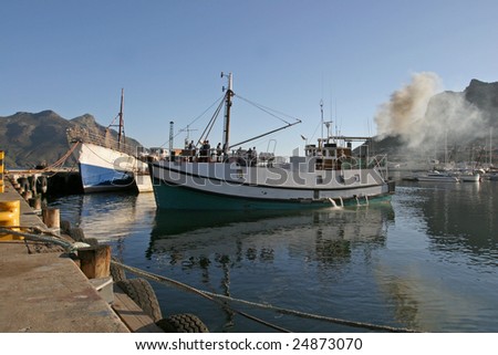 A trawler in Hout Bay harbor, Cape Town, preparing to go to sea.
