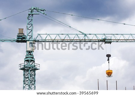 A close up of a gantry crane against a stormy sky