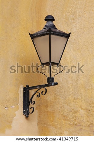 A wrought iron lamp on a weathered wall in Italy