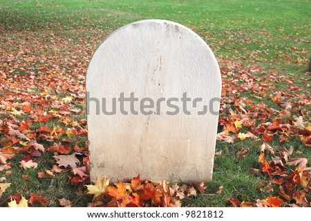 Blank tombstone amidst fall leaves - rest in peace.