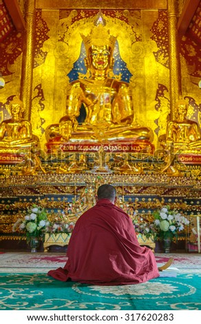 Buddhist monk sitting down in meditation pose inside the chapel