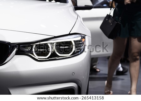 Closeup headlight of parking white car and opening door background