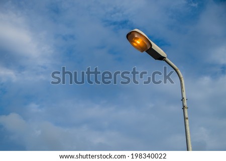 Street light pole with a blue sky background.