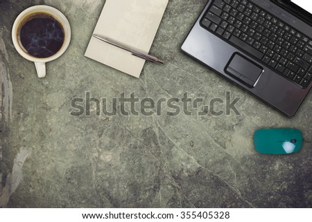 Office marble desk with computer, supplies, coffee cup and flower. Top view with copy space