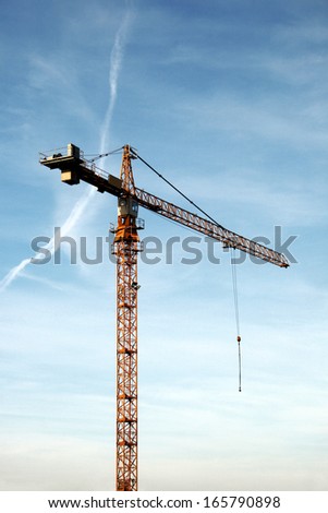 Tower crane at the work. The crane is in movement.