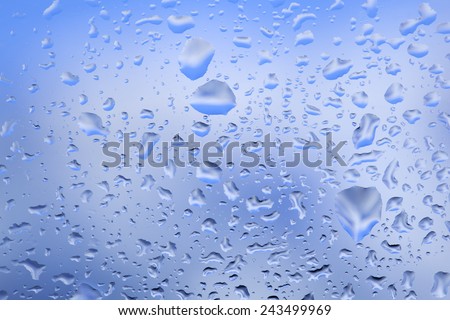look at the blue sky through the window with raindrops