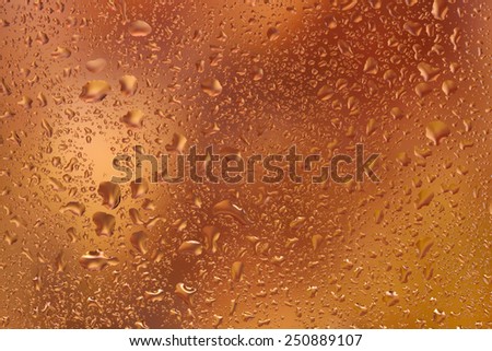 look at the bright autumn leaves through the glass with raindrops
